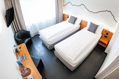 Ein Bett oder Betten in einem Zimmer der Unterkunft Hotel Merkur - West Station
