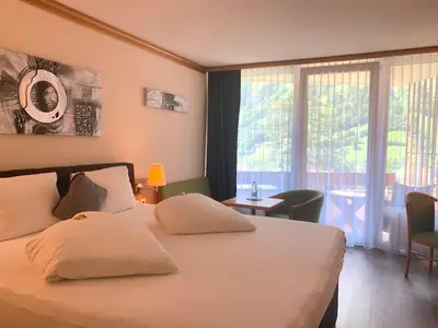 Ein Bett oder Betten in einem Zimmer der Unterkunft Hotel Quellenhof Leukerbad