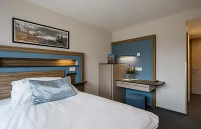 Ein Bett oder Betten in einem Zimmer der Unterkunft Hotel Metropole Interlaken