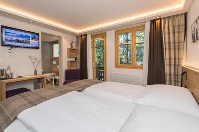 Ein Bett oder Betten in einem Zimmer der Unterkunft Hotel Bella Vista Zermatt