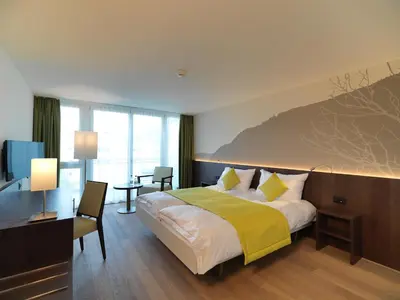 Ein Bett oder Betten in einem Zimmer der Unterkunft Hotel Artos Interlaken