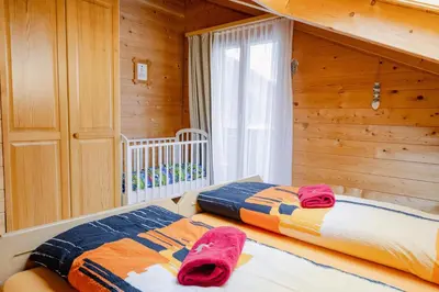 Ein Bett oder Betten in einem Zimmer der Unterkunft Chalet Regenbogen Leukerbad mit Indoorrutschbahn